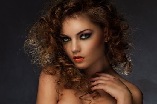 Beautiful caucasian woman with curls and evening makeup