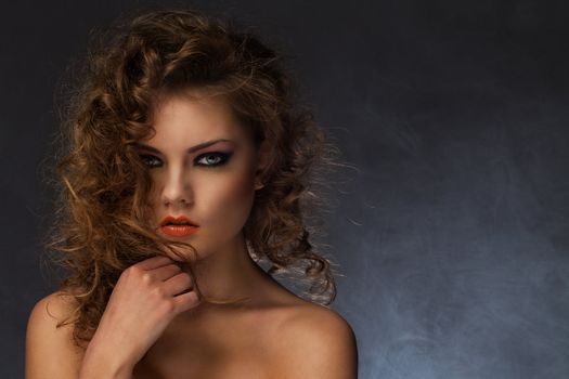 Beautiful caucasian woman with curls and evening makeup