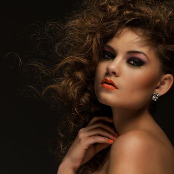 Beautiful caucasian woman with curls and evening makeup