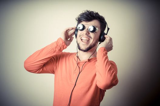 Stylish man listening to music on vignetting background