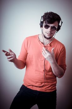 Stylish man listening to music on vignetting background