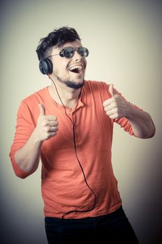 Stylish man listening to music on vignetting background