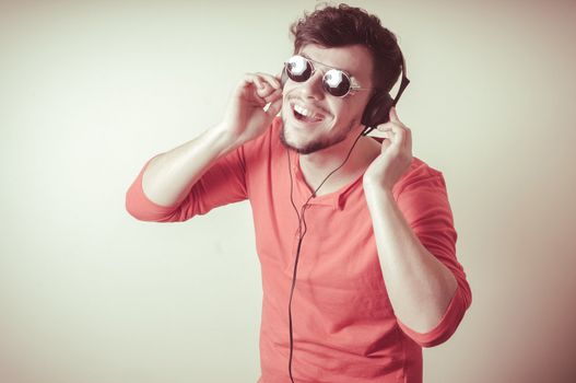 Stylish man listening to music on vignetting background