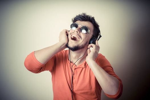 Stylish man listening to music on vignetting background