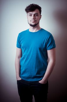 portrait of stylish young man with blue shirt on vignetting background