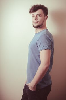 portrait of stylish young man with blue shirt on vignetting background