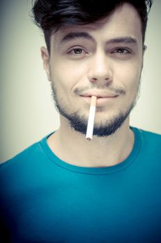 stylish young modern man with cigarette on vignetting background