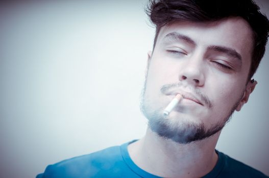 stylish young modern man with cigarette on vignetting background