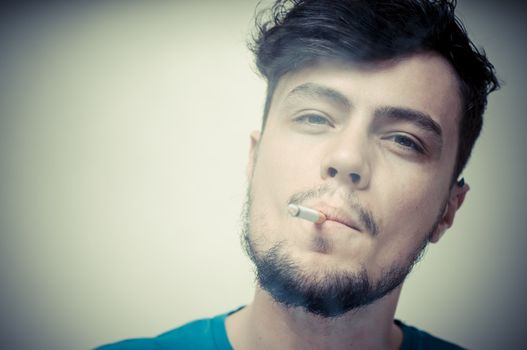 stylish young modern man with cigarette on vignetting background
