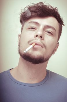 stylish young modern man with cigarette on vignetting background
