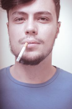 stylish young modern man with cigarette on vignetting background