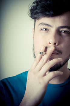 stylish young modern man with cigarette on vignetting background