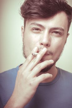 stylish young modern man with cigarette on vignetting background