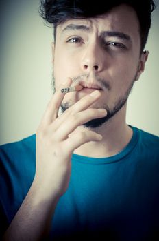 stylish young modern man with cigarette on vignetting background
