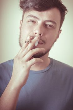 stylish young modern man with cigarette on vignetting background