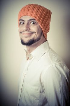 young modern stylish man with orange cap on vignetting background