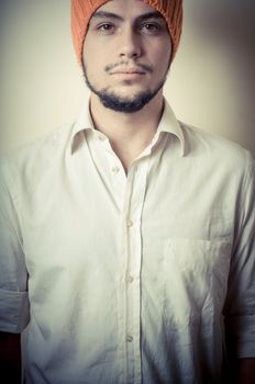 young modern stylish man with orange cap on vignetting background