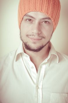 young modern stylish man with orange cap on vignetting background