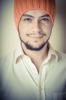 young modern stylish man with orange cap on vignetting background