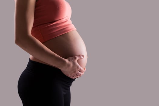 Beautiful pregnant belly on a grey background