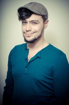 young modern stylish man with cap on vignetting background