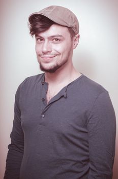 young modern stylish man with cap on vignetting background