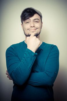young modern stylish man with cap on vignetting background