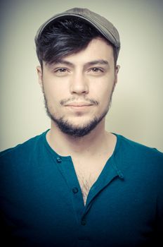 young modern stylish man with cap on vignetting background