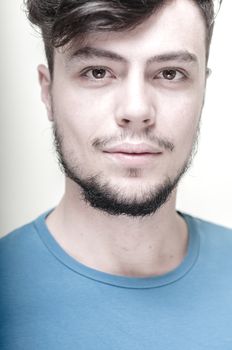 portrait of stylish young man with blue shirt on vignetting background