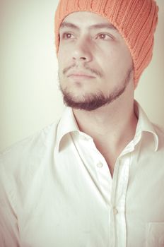 young modern stylish man with orange cap on vignetting background