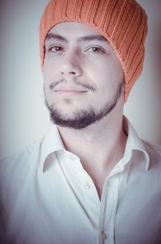 young modern stylish man with orange cap on vignetting background