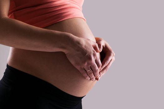 Beautiful pregnant belly on a grey background