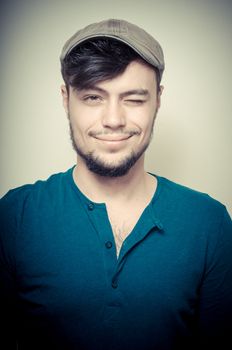 young modern stylish man with cap on vignetting background