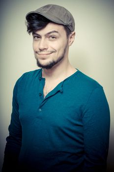 young modern stylish man with cap on vignetting background