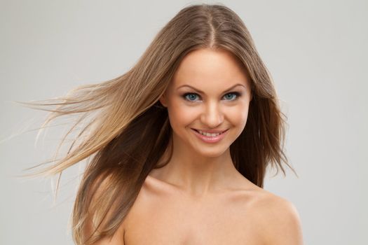 Beautiful young caucasian woman with natural makeup over grey background