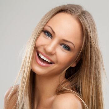 Beautiful young caucasian woman with natural makeup over grey background