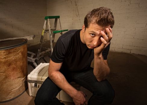 Stressed out European man sitting in warehouse