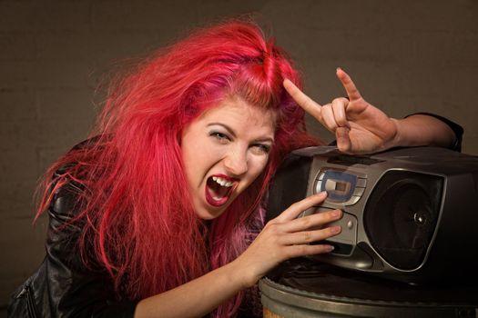 Excited teenager with pink hair and radio making hand gesture