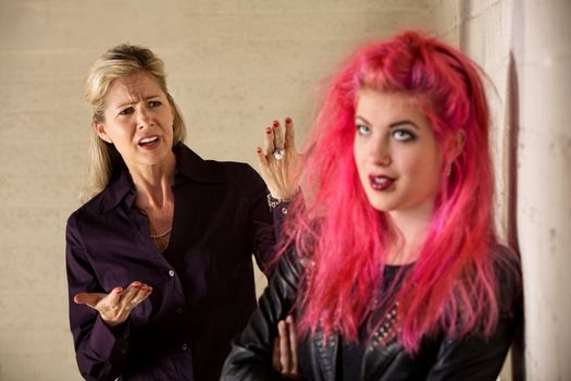 Angry mother with teenage daughter in leather jacket