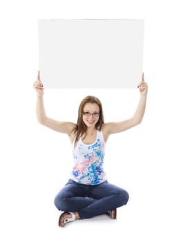 Front view of a teenage girl sitting on floor and holding up a empty billboard.