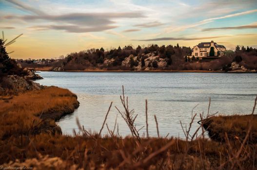 House overlooking the ocean at sunset on the coastline along Rhode Island.