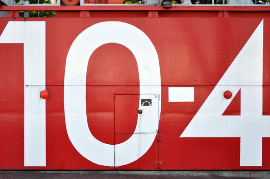a red japanese tsunami watertight door in osaka bay area with the number 10-4 painted on it 