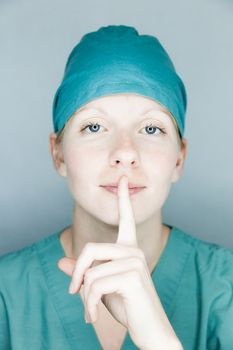 Young nurse in studio on a gray background