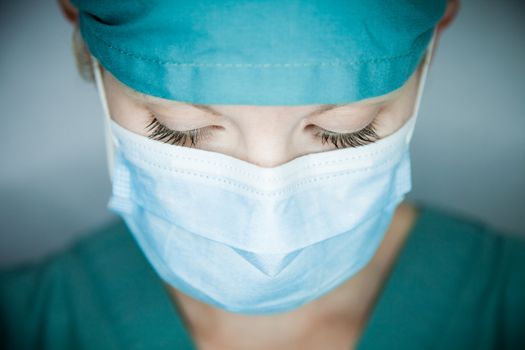 Young nurse in studio on a gray background