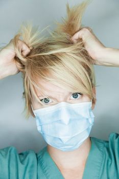 Young nurse in studio on a gray background