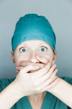 Young nurse in studio on a gray background