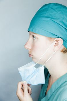 Young nurse in studio on a gray background