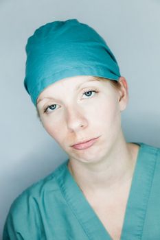 Young nurse in studio on a gray background