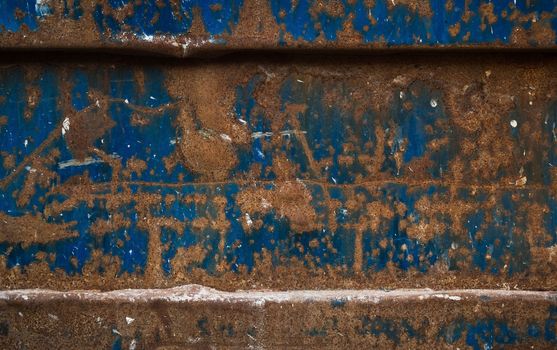 This is a really old and rusty blue painted metal dumpster. This is a good color contrast... blue and orange is like hot and cold.