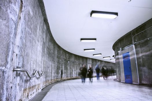 A nice grunge corridor with a blue door. It was a very dark and weird place. This passage is part of a Montreal metro station. This is how to transit from a metro to an other (to change line). This picture was during the rush hour and you can see many people passing by.